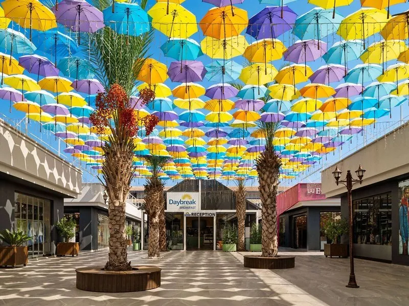 Atrij nakupovalnega središča s pisanimi dežniki nad glavo