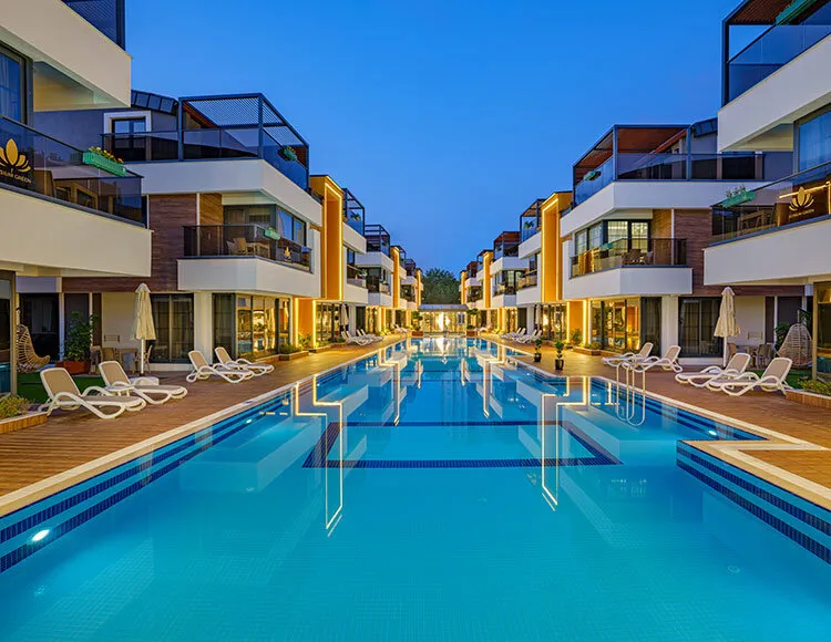 Osvetljen hotelski bazen ponoči z moderno arhitekturo suit