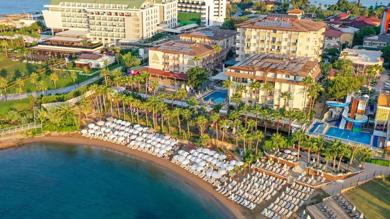 Zračni posnetek hotela EOS Beach Resort s pogledom na plažo, bazene in vodne tobogane.