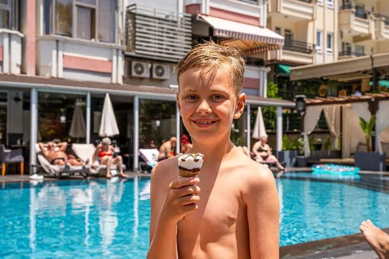 Otrok uživa v sladoledu ob zunanjem bazenu hotela HMA