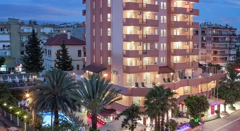 Nočni pogled na osvetljen hotel May Flower z bazenom v ospredju.