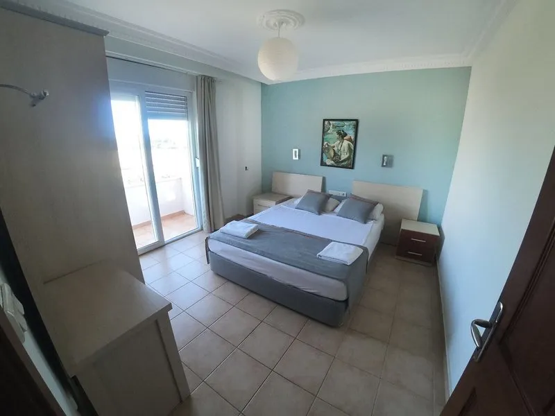 Svetla spalnica z zakonsko posteljo in balkonom