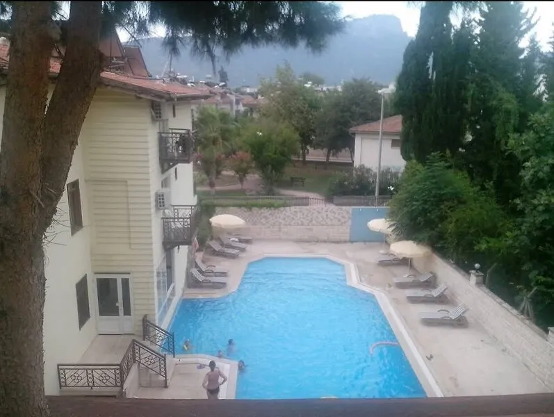 Zunanji bazen z ležalniki in pogledom na gore v ozadju