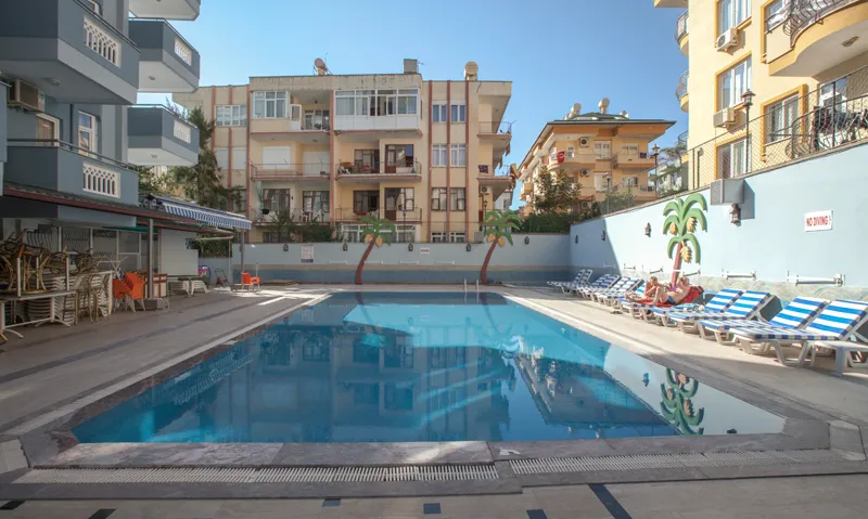 Zunanji bazen z ležalniki pred apartmajsko zgradbo