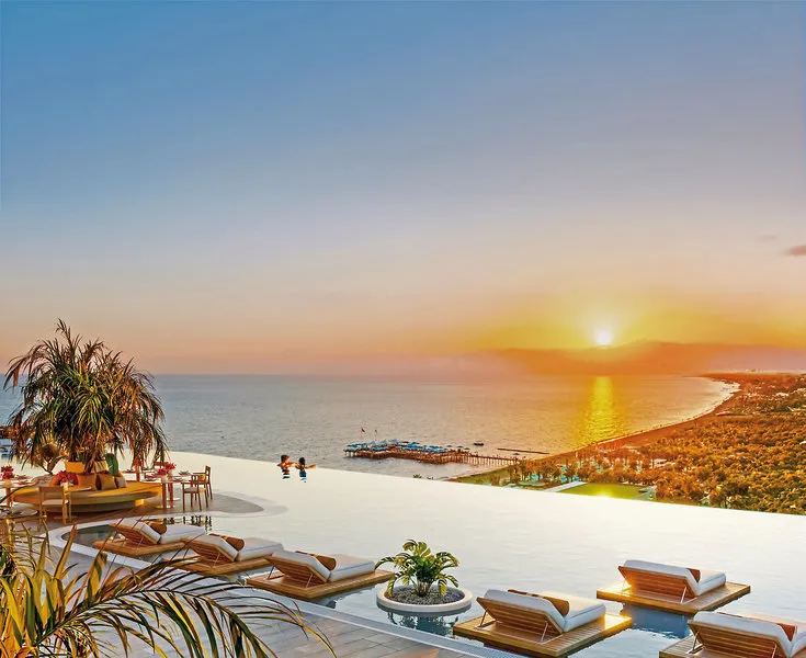 Infinity bazen na strehi s pogledom na morje ob sončnem zahodu