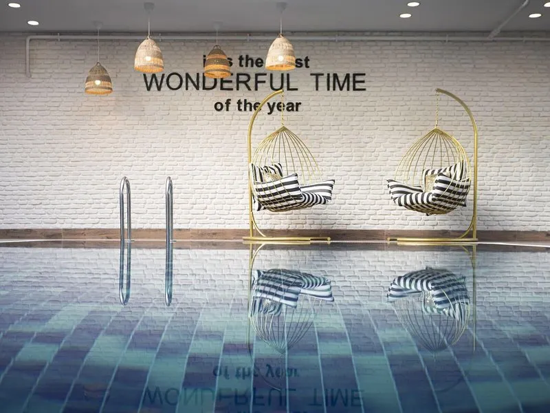 Notranji bazen z visečimi stoli in napisom na steni