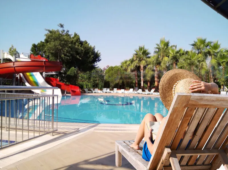 Sprostitev na ležalniku ob bazenu z vodnimi tobogani